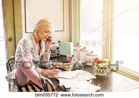 Caucasian woman paying bills on telephone in kitchen View Large Photo Image Stock Image - Caucasian woman paying bills on telephone in kitchen. Fotosearch