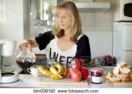 Caucasian woman pouring coffee in kitchen View Large Photo Image Stock Image - Caucasian woman pouring coffee in kitchen. Fotosearch
