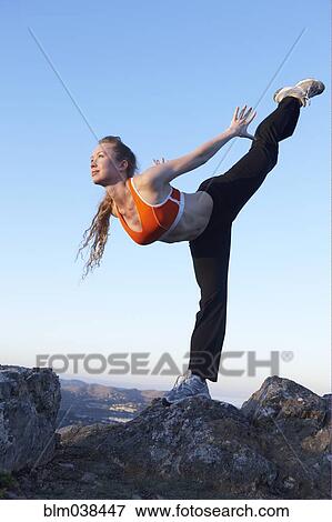 Stock Photo - Caucasian woman practicing yoga on mountaintop. Fotosearch