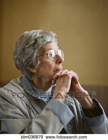 Stock Photo - Caucasian woman resting chin on clasped hands. Fotosearch