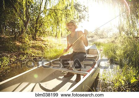 Caucasian woman rowing canoe in rural creek View Large Photo Image Stock Photo - Caucasian woman rowing canoe in rural creek. Fotosearch