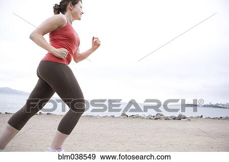 Stock Photo - Caucasian woman running on beach. Fotosearch