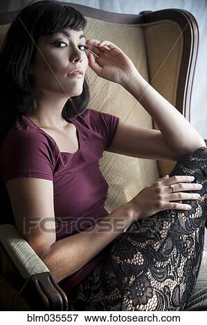 Stock Photo - Caucasian woman sitting in armchair. Fotosearch