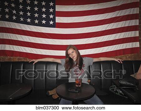 Caucasian woman sitting under American flag in restaurant View Large Photo Image Stock Image - Caucasian woman sitting under American flag in restaurant. Fotosearch