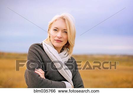 Stock Photograph - Caucasian woman standing in cold rural field. Fotosearch