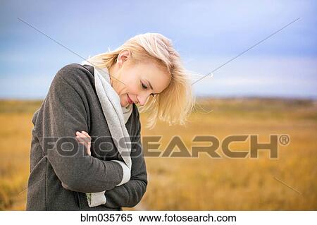 Stock Photography - Caucasian woman standing in cold rural field. Fotosearch