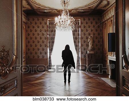 Stock Image - Caucasian woman standing in ornate room. Fotosearch
