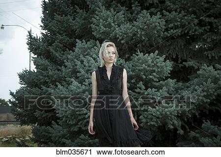 Caucasian woman standing near evergreen tree View Large Photo Image Stock Image - Caucasian woman standing near evergreen tree. Fotosearch