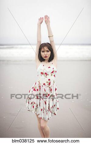 Stock Photography - Caucasian woman standing on beach. Fotosearch