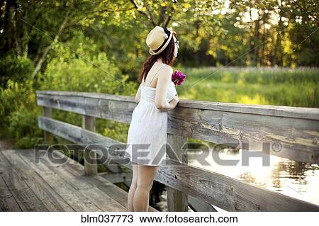 Caucasian woman standing on bridge over rural pond View Large Photo Image Stock Image - Caucasian woman standing on bridge over rural pond. Fotosearch
