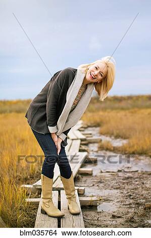 Caucasian woman standing on walkway in rural field View Large Photo Image Picture - Caucasian woman standing on walkway in rural field. Fotosearch