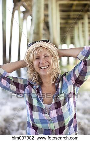 Caucasian woman standing under boardwalk on beach View Large Photo Image Stock Image - Caucasian woman standing under boardwalk on beach. Fotosearch