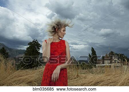Stock Photography - Caucasian woman tossing her hair in tall grass. Fotosearch