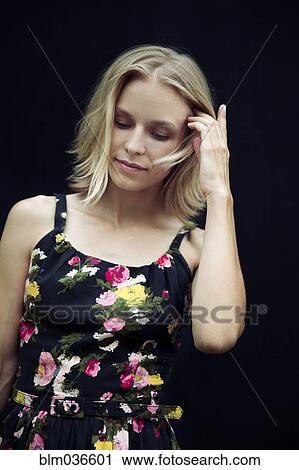 Stock Image - Caucasian woman tucking hair behind ear. Fotosearch