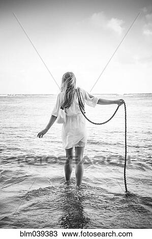 Caucasian woman wading in ocean waves holding rope View Large Photo Image Stock Image - Caucasian woman wading in ocean waves holding rope. Fotosearch