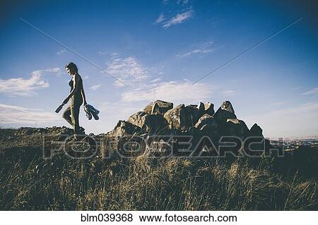Stock Photo - Caucasian woman walking in rural field. Fotosearch