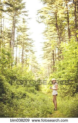 Caucasian woman walking on grass path in forest View Large Photo Image Stock Photo - Caucasian woman walking on grass path in forest. Fotosearch