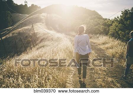 Caucasian woman walking on rural dirt road View Large Photo Image Stock Image - Caucasian woman walking on rural dirt road. Fotosearch