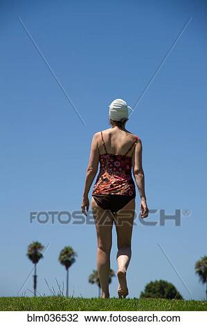 Stock Image - Caucasian woman wearing bathing suit in grass. Fotosearch