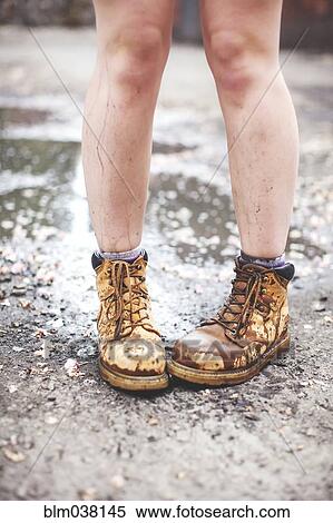 Stock Photography - Caucasian woman wearing dirty boots. Fotosearch