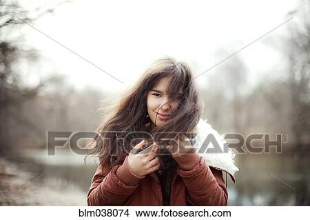 Picture - Caucasian woman wearing furry coat outdoors. Fotosearch