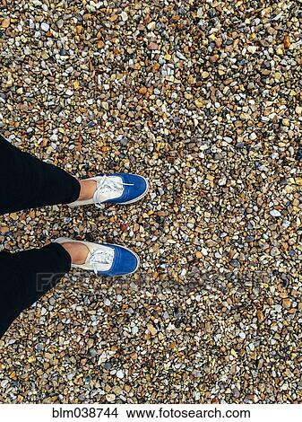 Caucasian woman wearing sneakers in pebbles View Large Photo Image Picture - Caucasian woman wearing sneakers in pebbles. Fotosearch