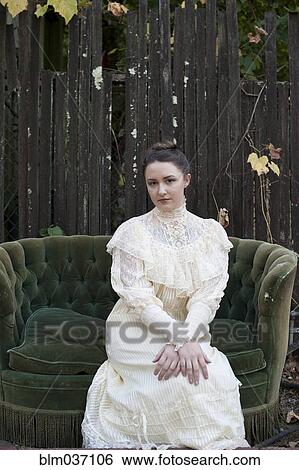Caucasian woman wearing vintage gown on backyard sofa View Large Photo Image Stock Photograph - Caucasian woman wearing vintage gown on backyard sofa. Fotosearch