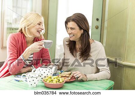 Picture - Caucasian women drinking tea and laughing. Fotosearch