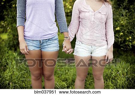 Caucasian women holding hands in rural field View Large Photo Image Stock Image - Caucasian women holding hands in rural field. Fotosearch