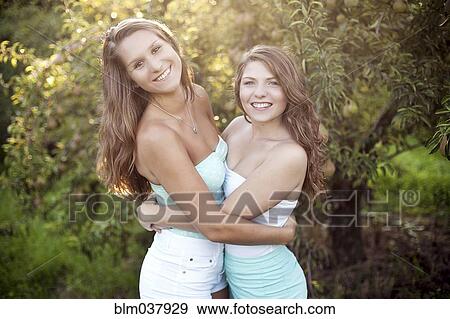 Stock Photo - Caucasian women hugging in garden. Fotosearch