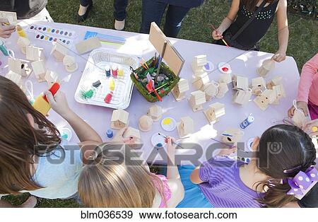 Stock Photo - Children doing arts and crafts in backyard. Fotosearch