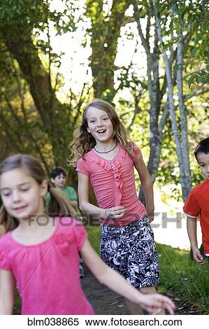 Stock Photography - Children running on dirt path in park. Fotosearch