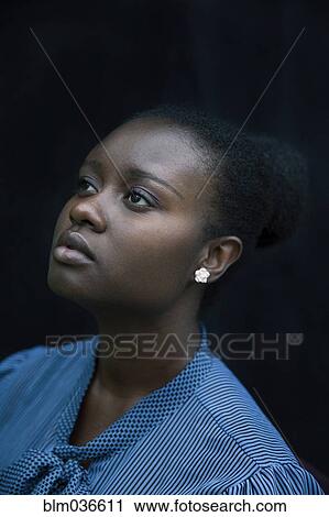 Stock Image - Close up of Black woman looking up. Fotosearch