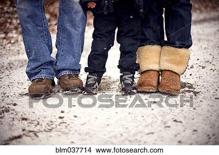 Close up of boots of family standing in snow View Large Photo Image Picture - Close up of boots of family standing in snow. Fotosearch