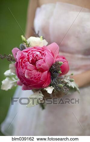 Stock Image - Close up of bride holding bouquet of flowers. Fotosearch