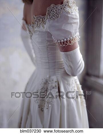 Stock Image - Close up of bride wearing wedding gown. Fotosearch