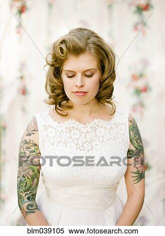 Stock Photography - Close up of bride with tattoos wearing wedding dress. Fotosearch