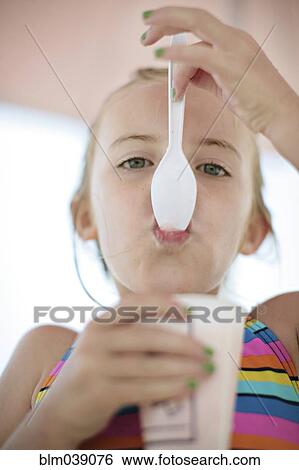 Stock Photograph - Close up of Caucasian girl eating ice cream. Fotosearch