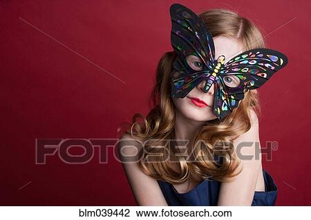 Stock Image - Close up of Caucasian girl wearing butterfly mask. Fotosearch