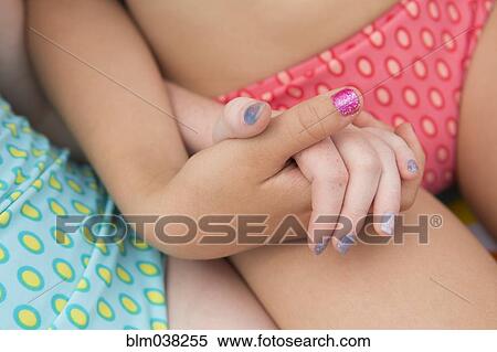 Stock Photography - Close up of Caucasian girls holding hands. Fotosearch