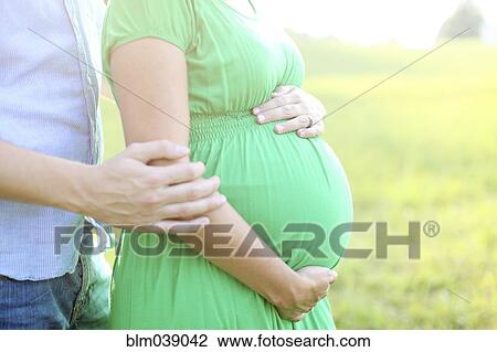Stock Image - Close up of Caucasian man hugging pregnant wife. Fotosearch