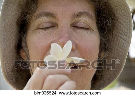 Close up of Caucasian woman smelling flower View Large Photo Image Picture - Close up of Caucasian woman smelling flower. Fotosearch