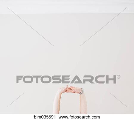 Stock Image - Close up of Caucasian woman stretching arms in midair. Fotosearch