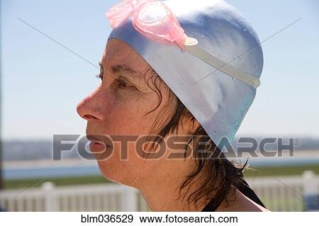 Stock Photo - Close up of Caucasian woman wearing swim cap and goggles. Fotosearch