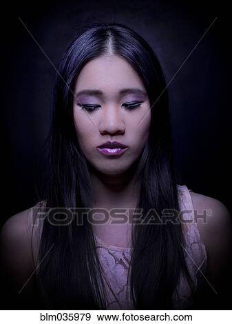 Close up of Chinese woman with long hair looking down View Large Photo Image Stock Photo - Close up of Chinese woman with long hair looking down. Fotosearch