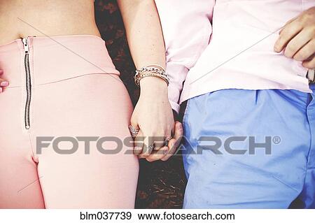 Stock Photo - Close up of couple holding hands. Fotosearch