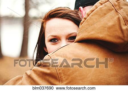 Stock Image - Close up of couple hugging in park. Fotosearch