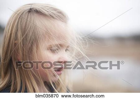 Stock Image - Close up of curious girl looking down . Fotosearch