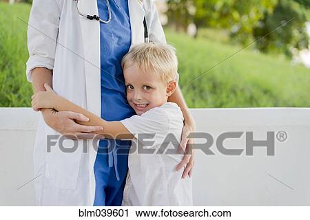 Close up of doctor and son hugging outdoors View Large Photo Image Stock Image - Close up of doctor and son hugging outdoors. Fotosearch