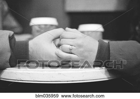 Stock Photo - Close up of engaged couple holding hands. Fotosearch